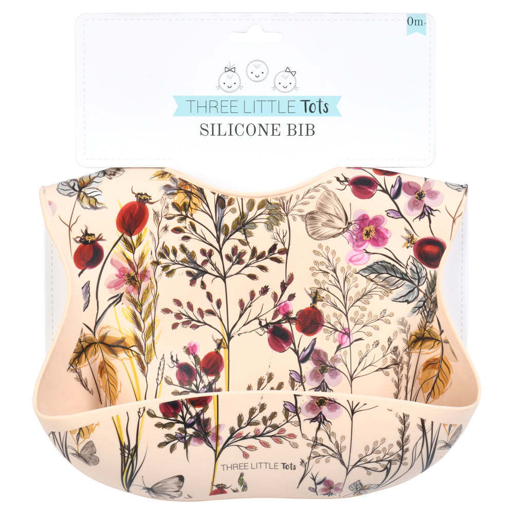 Little girl eating with a Three Little Tots floral silicone bib