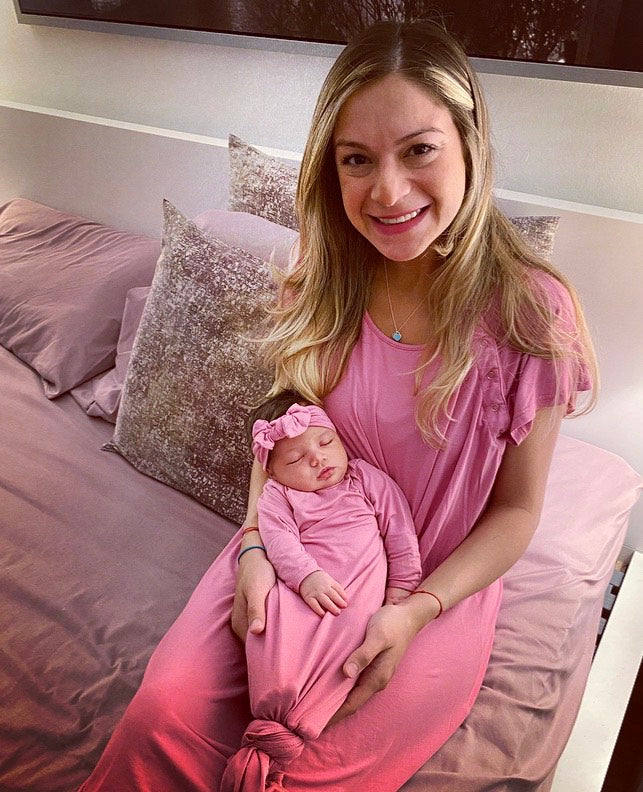 Mom in the Three Little Tots labor and delivery gown holding her newborn baby girl in the Three Little Tots Knotted Baby Gown