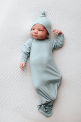 newborn baby with open eyes photoshoot with a knotted baby gown