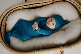 plum + sparrow baby Moses basket with newborn baby in a knotted gown