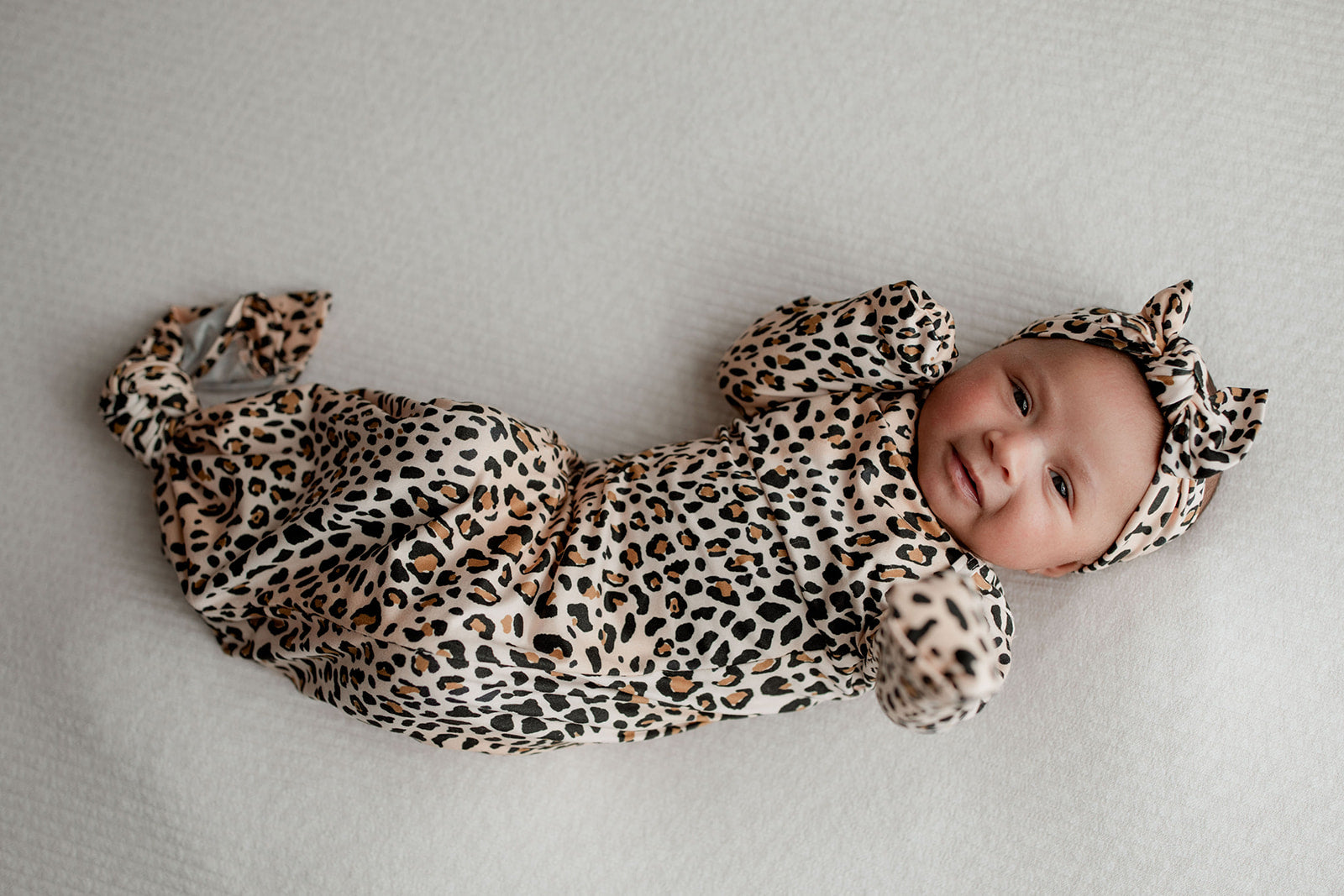 Three Little Tots Knotted baby gown features fold over mittens and a tie bottom that mimics the womb to bring comfort to newborns.