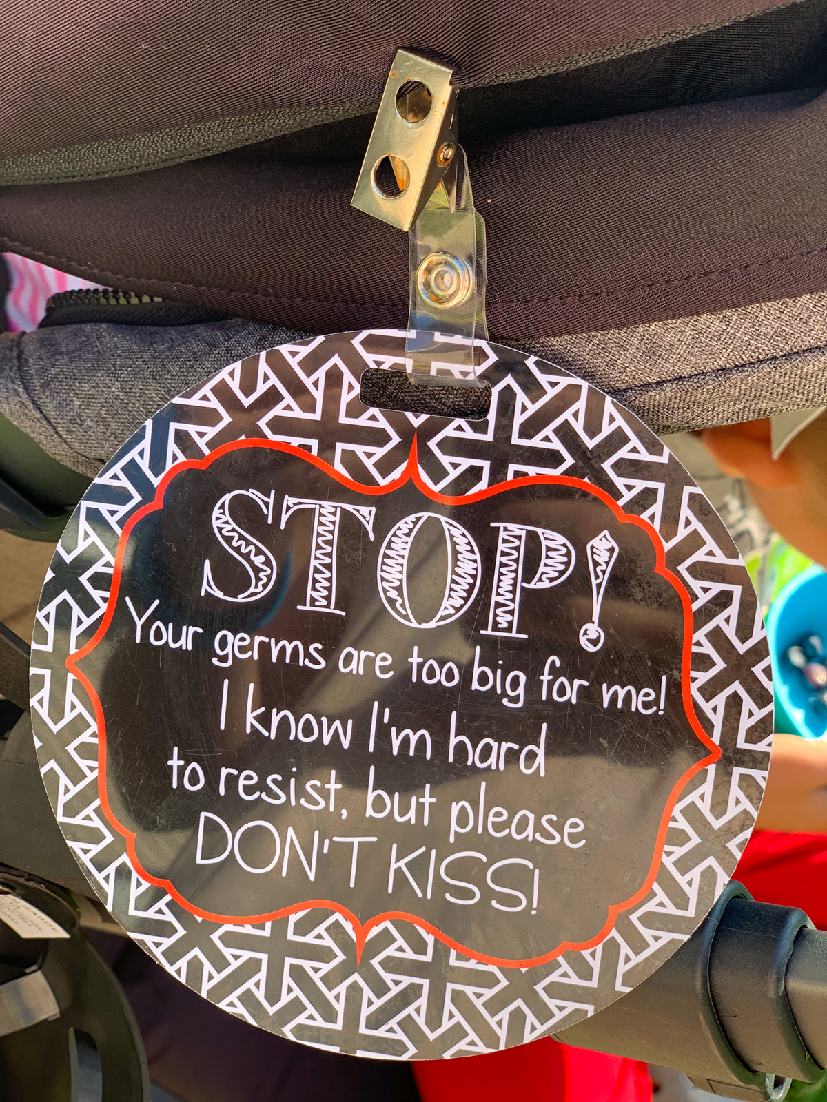 Three Little Tots No Kissing Sign on a Stroller using the clip attachment