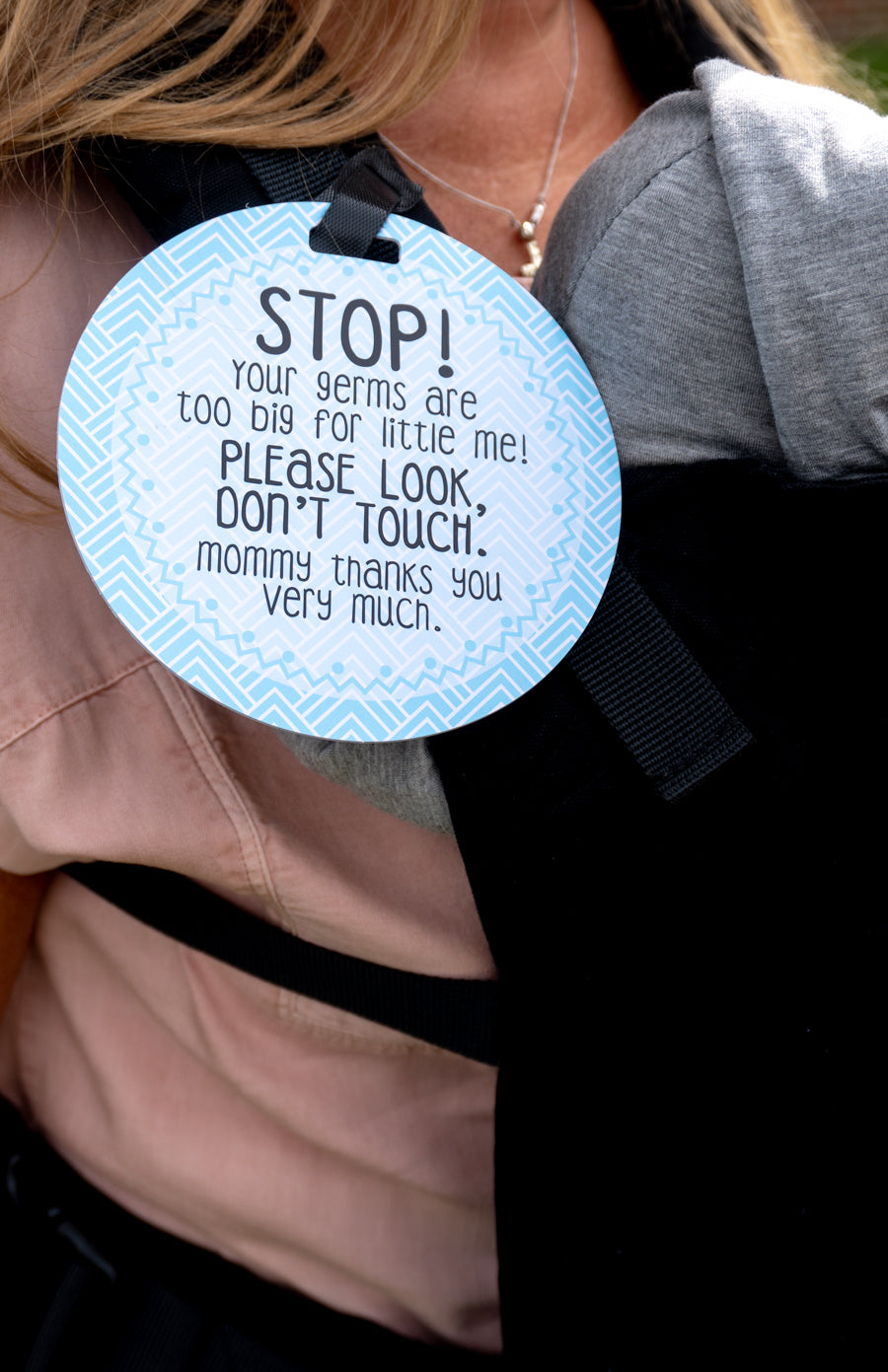 newborn baby in a carrier. People will still try and touch your newborn. Protect your newborn with a Three Little Tots tag.
