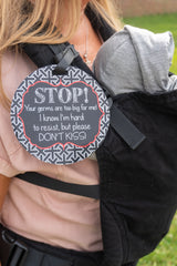 Three Little Tots no kissing sign on a baby carrier