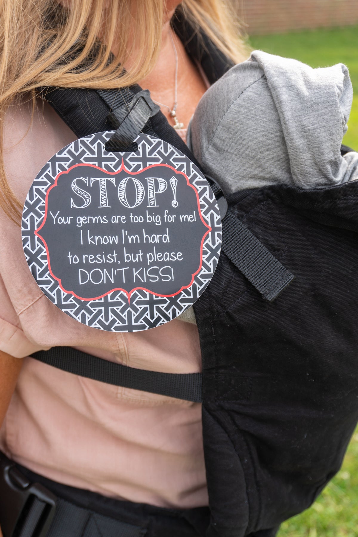 Three Little Tots no kissing sign on a baby carrier