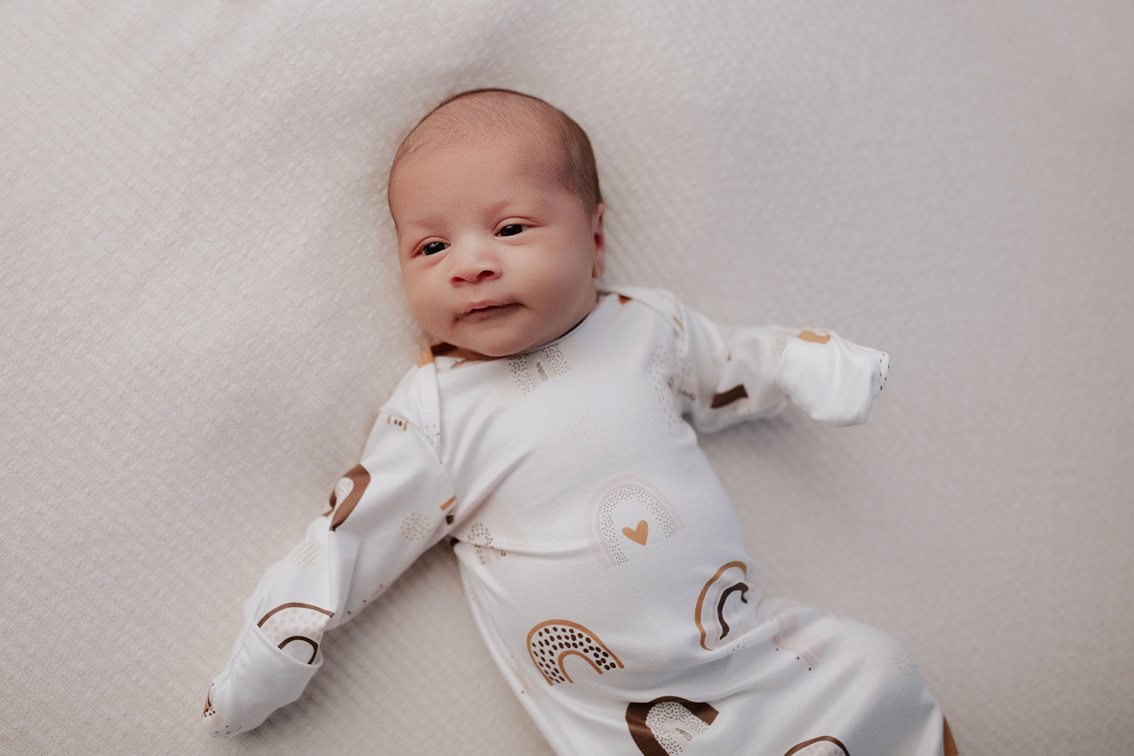 Fold over mittens on Three Little Tots Rainbow knotted baby gown helps to mimic the womb and gives the baby comfort