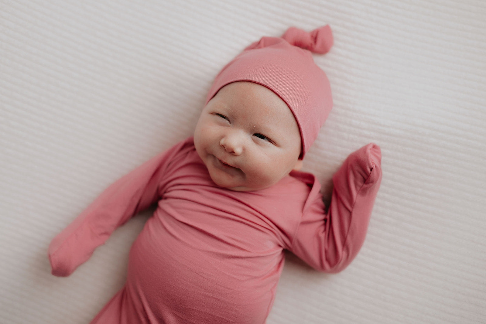 Luxuriously soft modal knotted baby gowns for newborn babies, offering comfort, easy diaper changes, and style. Three Little Tots Rose Pink Knotted baby gown. Knotted tie bottom mimics the womb to bring comfort to your newborn