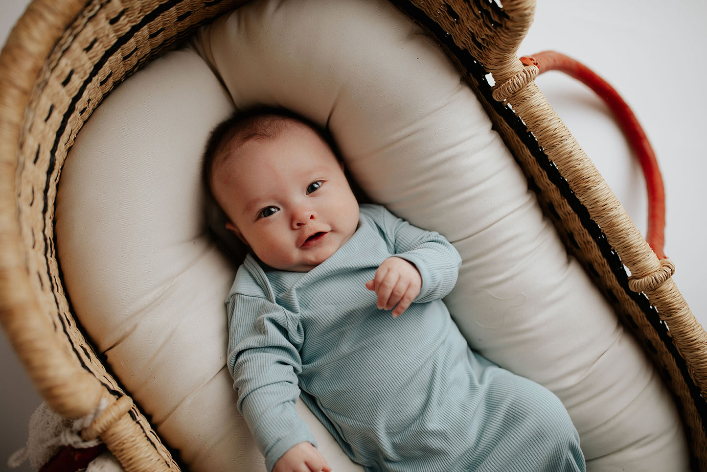 Newborn photoshoot with a Plum + Sparrow Moses basket and a Three Little Tots newborn knotted baby gown